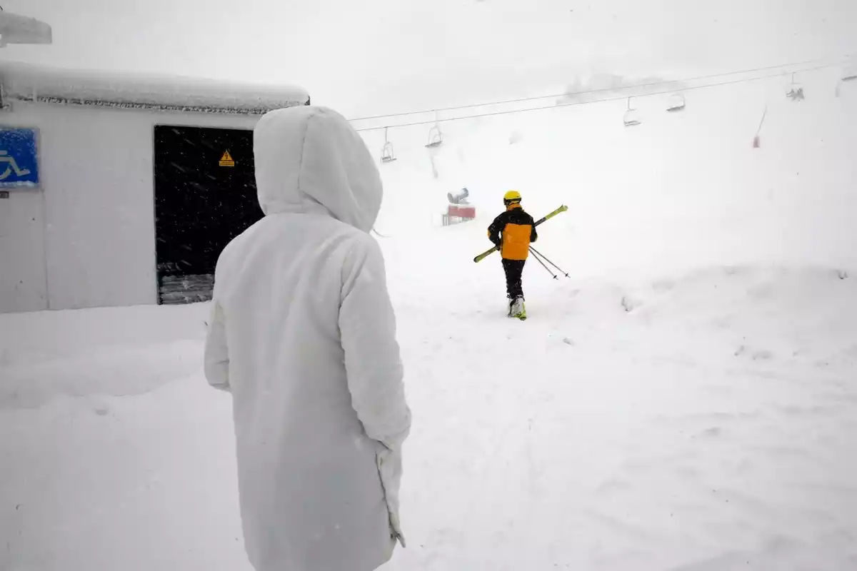 Dos personas andando por una estación de esquí