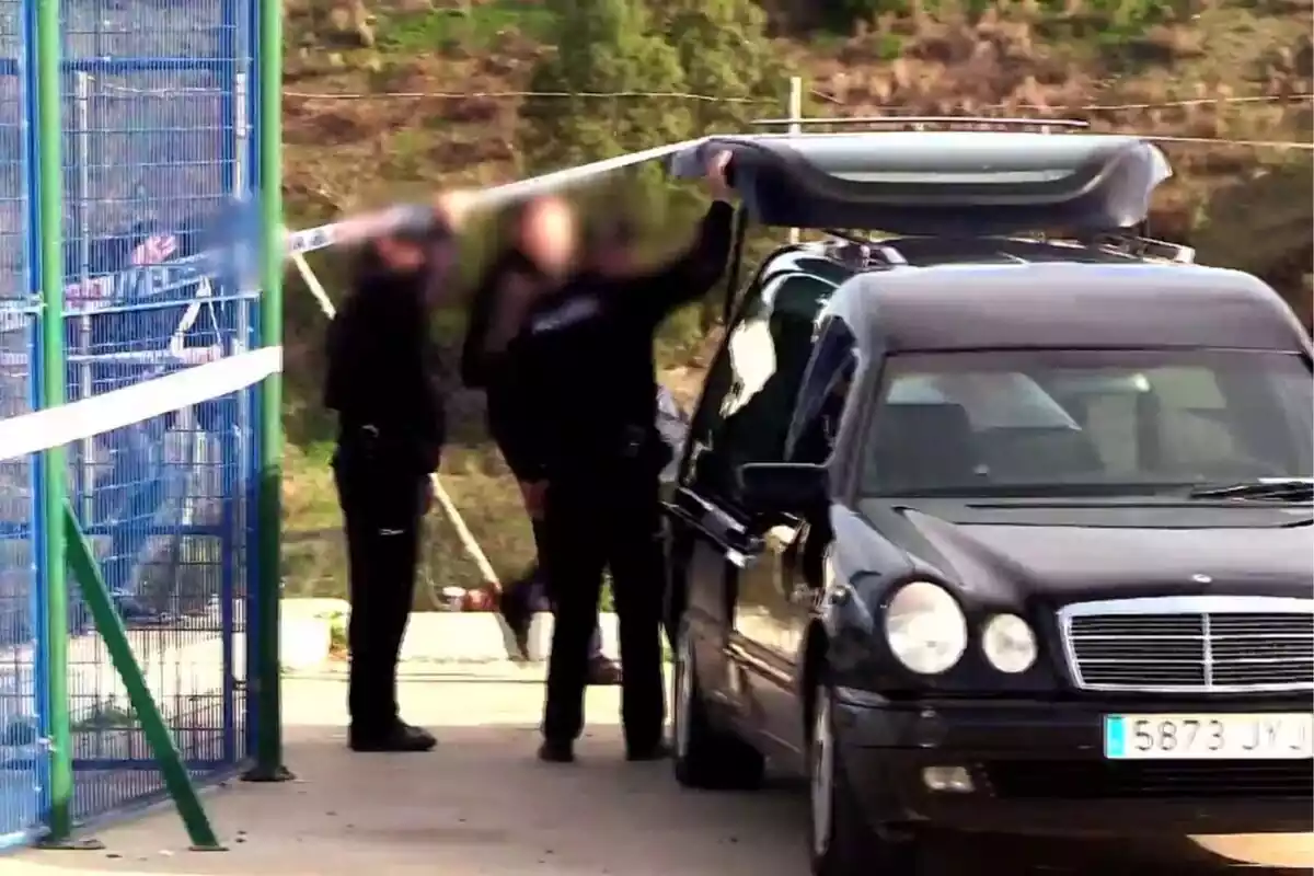 Policía junto al coche funerario