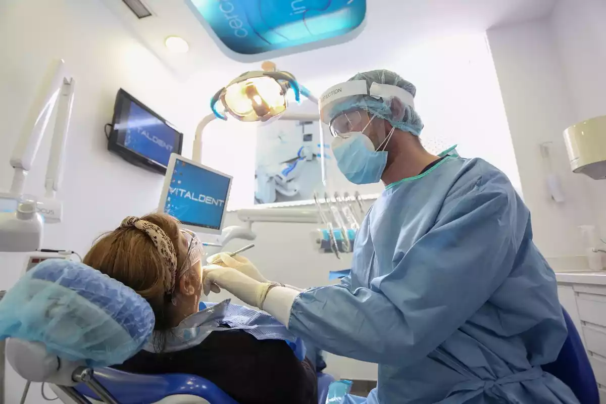 Un dentista atendiendo a una mujer en su consulta