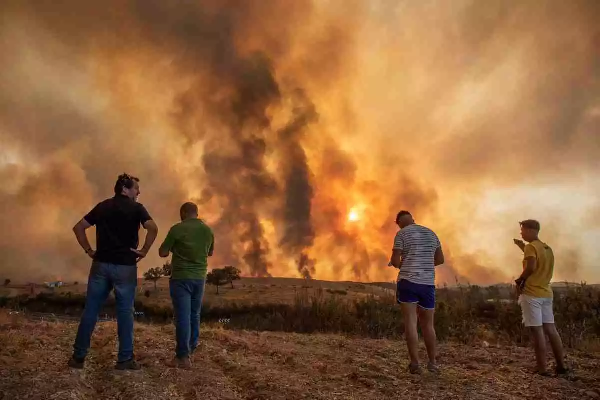 Vecinos observan el incendio forestal declarado en el Paraje Olivargas de Almonaster la Real, en Huelva, el 27 de agosto del 2020