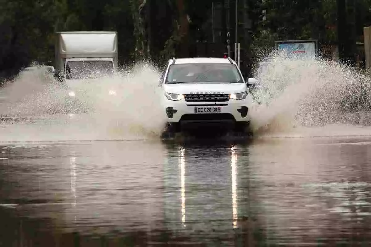 Imagen de un coche cruzando un tramo de carretera inundado