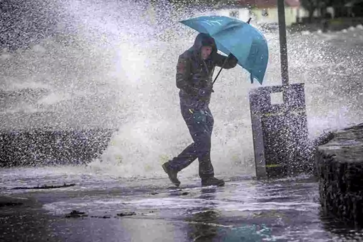 Imagen de un hombre afectado por un fuerte temporal de viento y oleaje
