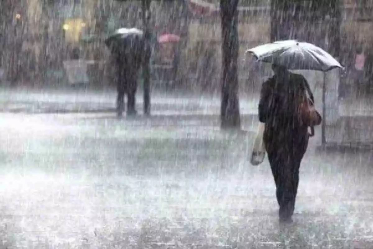 Imagen de una mujer caminando bajo la lluvia