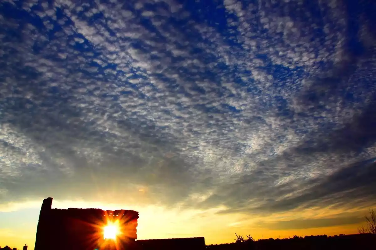 Imagen de una salida de sol entre nubes en Carrascoa del Campo, Castilla-la Mancha