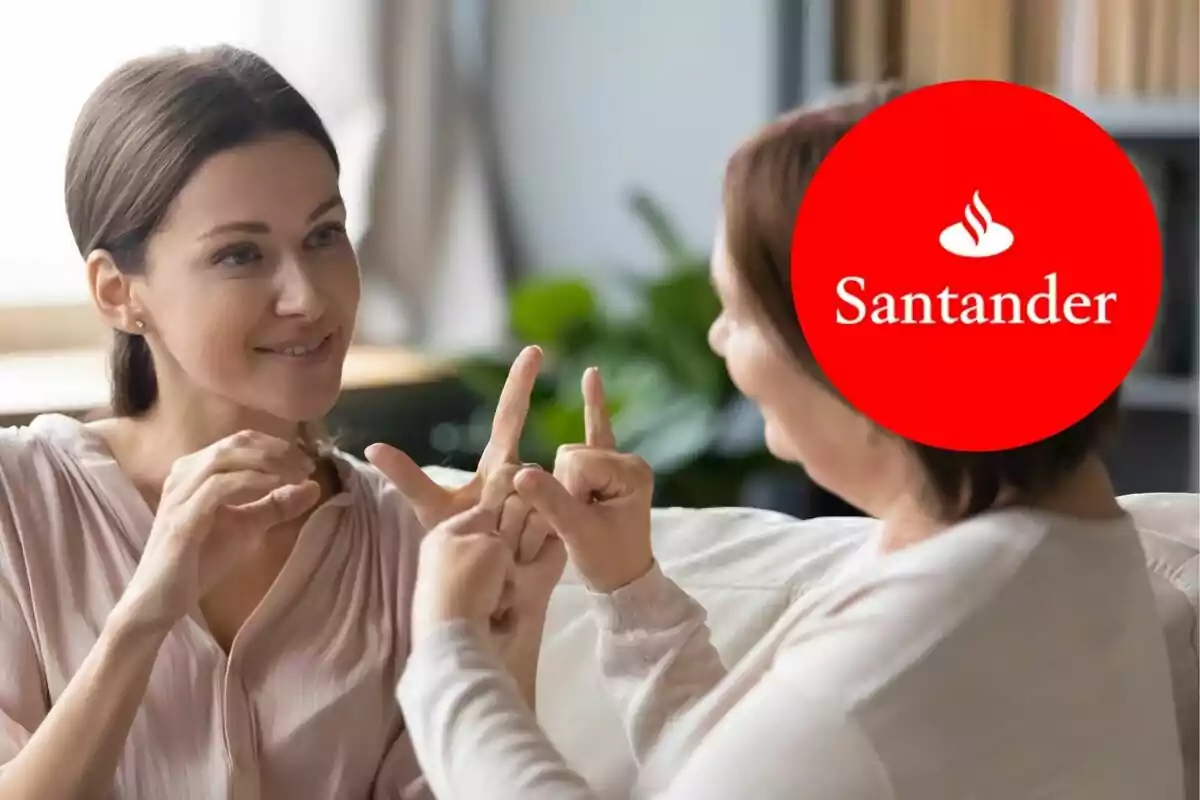 Dos personas comunicándose en lenguaje de señas con un logotipo del Banco Santander superpuesto. Dos personas comunicándose en lenguaje de señas con un logotipo del Banco Santander superpuesto.